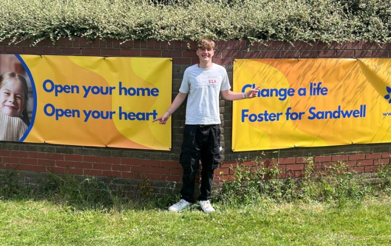 James standing outside our HQ pointing at our new banners